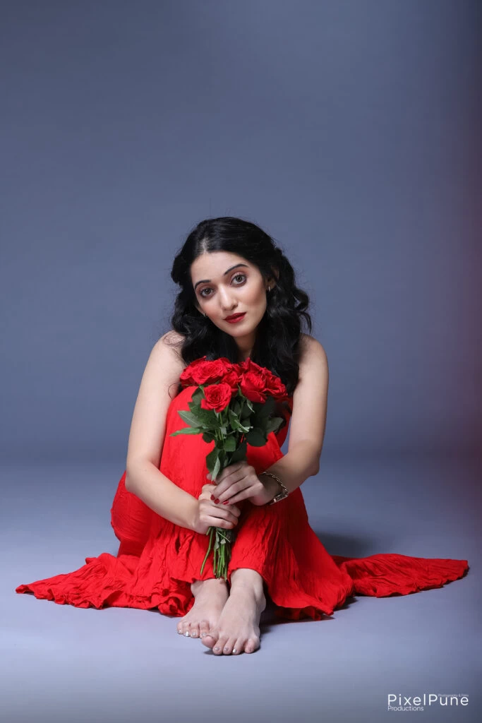 Manasi Patwardhan in red outfit holding roses