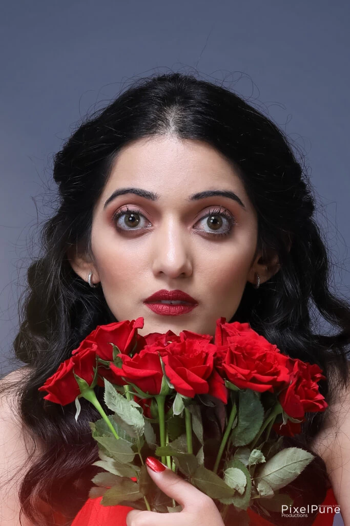 Manasi Patwardhan in red outfit holding roses